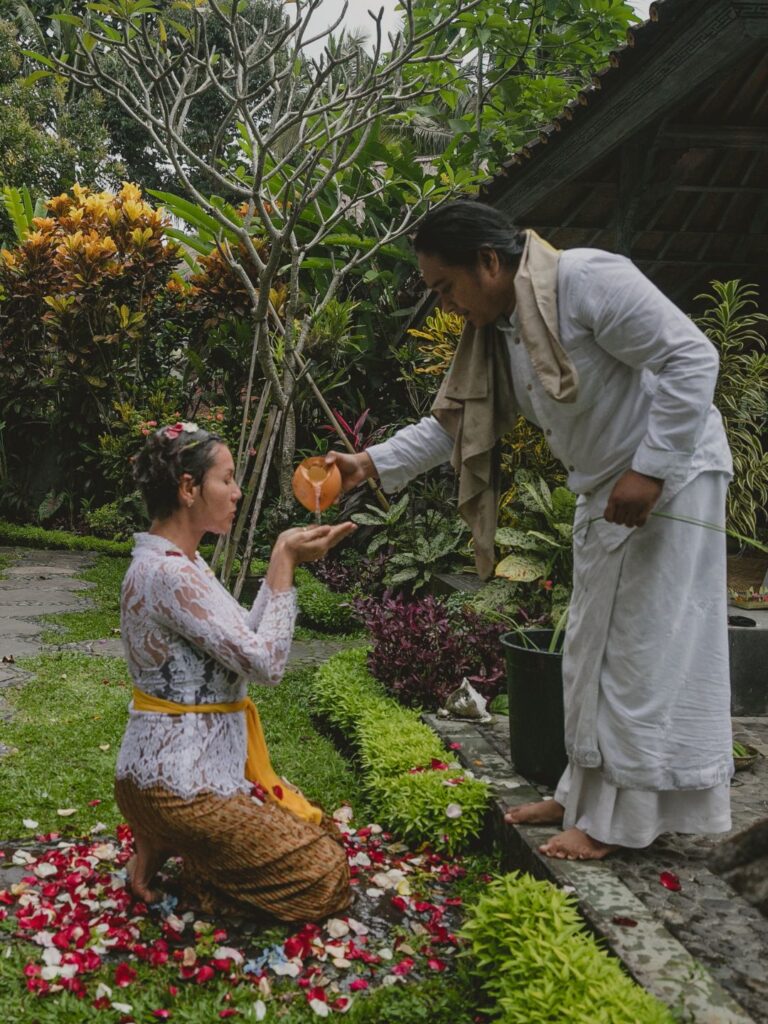 Joyful solo woman arms open feeling free at private villa luxury retreat Ubud Bali transformation